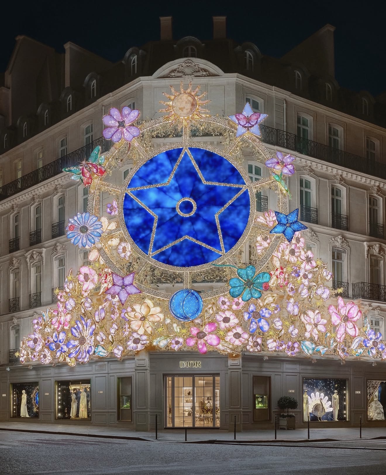 Grande installazione decorativa floreale temporanea con stella centrale su una facciata